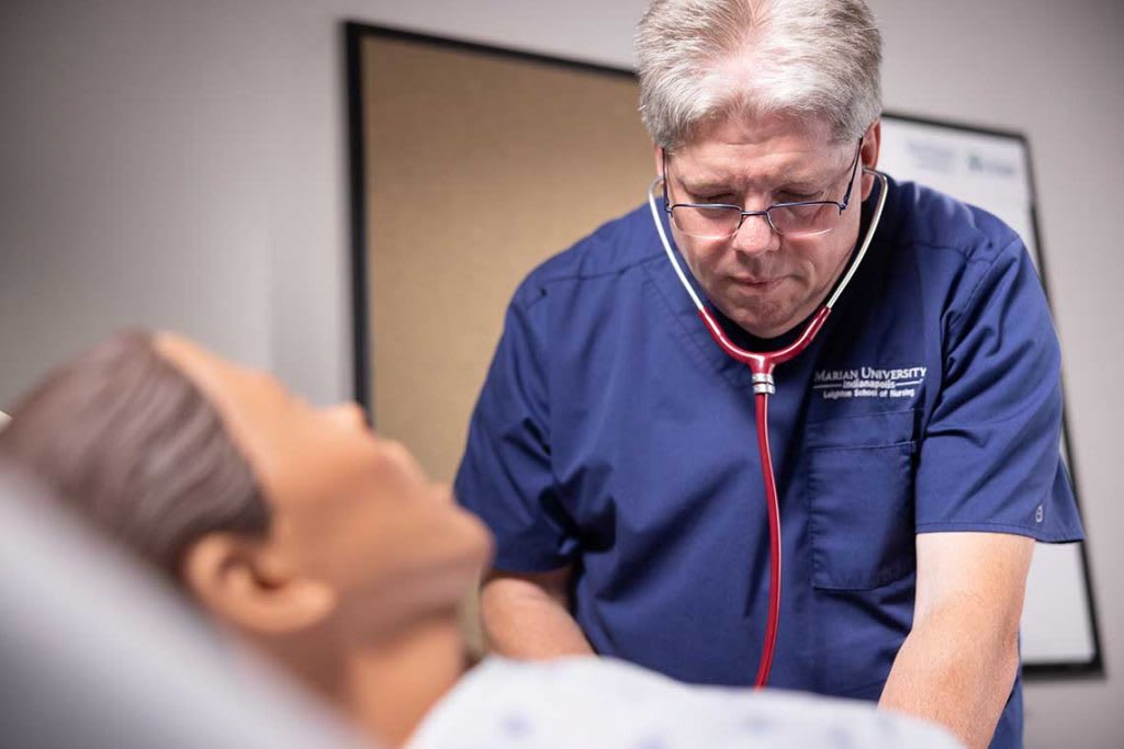 Marian nursing student working with sim manikin