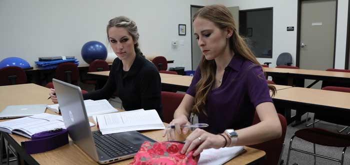 two OTA students studying on a computer