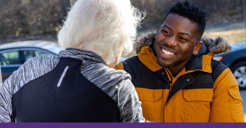 man in winter coat talking to woman outside