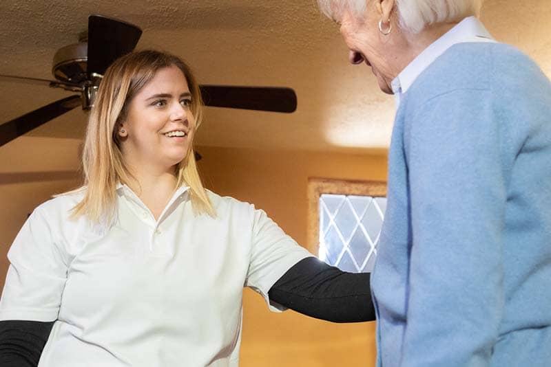 student smiling with elderly woman