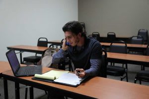 student in classroom talking on phone