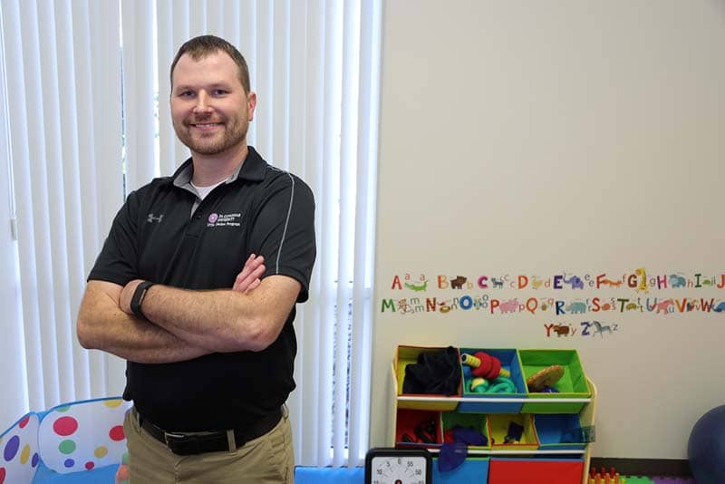 man smiling standing in a kids' play room