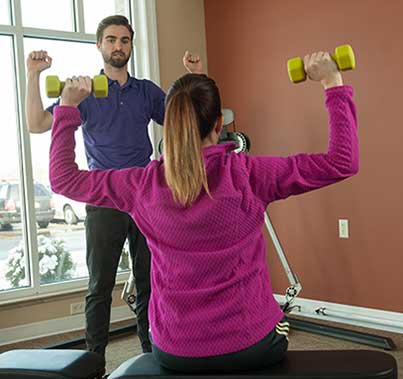 OT helping patient with lifting weights