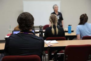 instructor lecturing at front of classroom