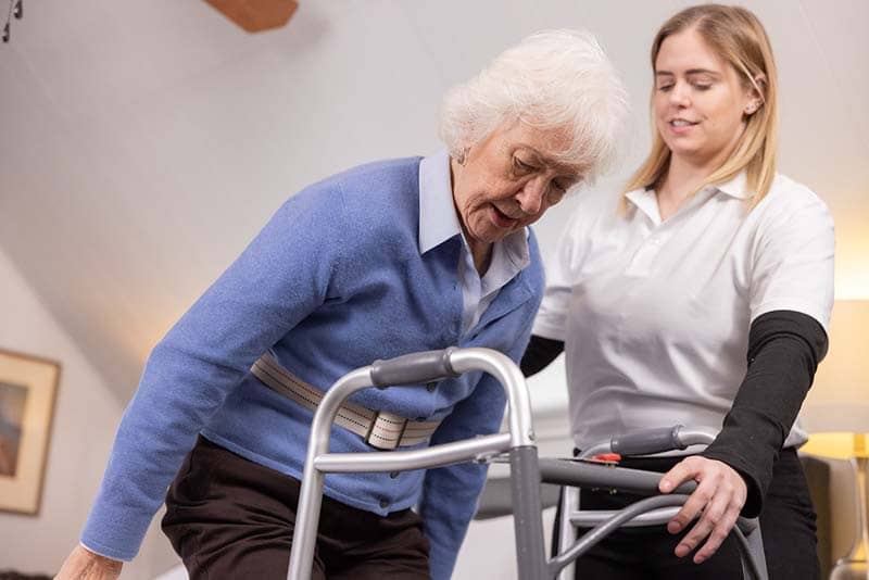 OT student helping older woman with walker