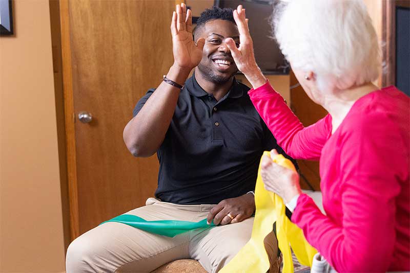 student high-fiving elderly woman