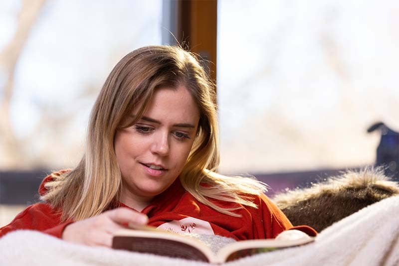 woman sitting in chair reading