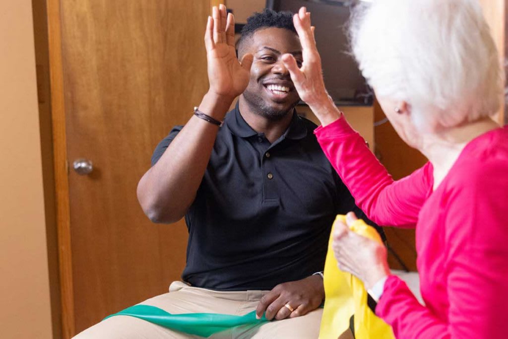 man high-fiving an elderly woman