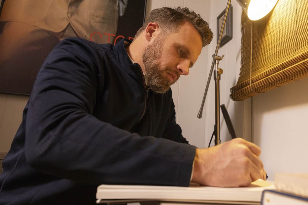 man at desk with books