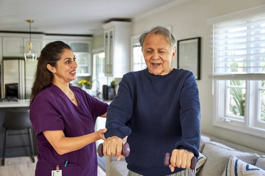 OT helping patient with holding weights