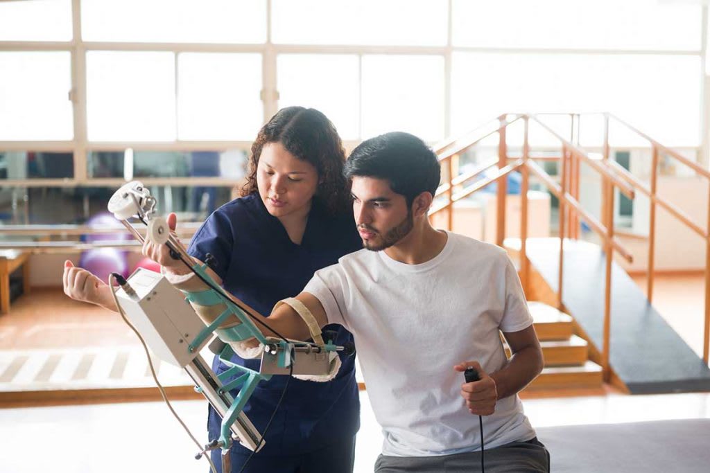 OT helping patient with arm brace