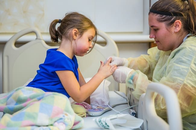 A nurse in a hospital treating a child.