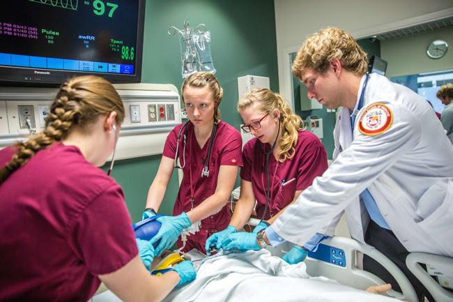 A nursing simulation lab in progress with four Loyola Chicago accelerated nursing students.