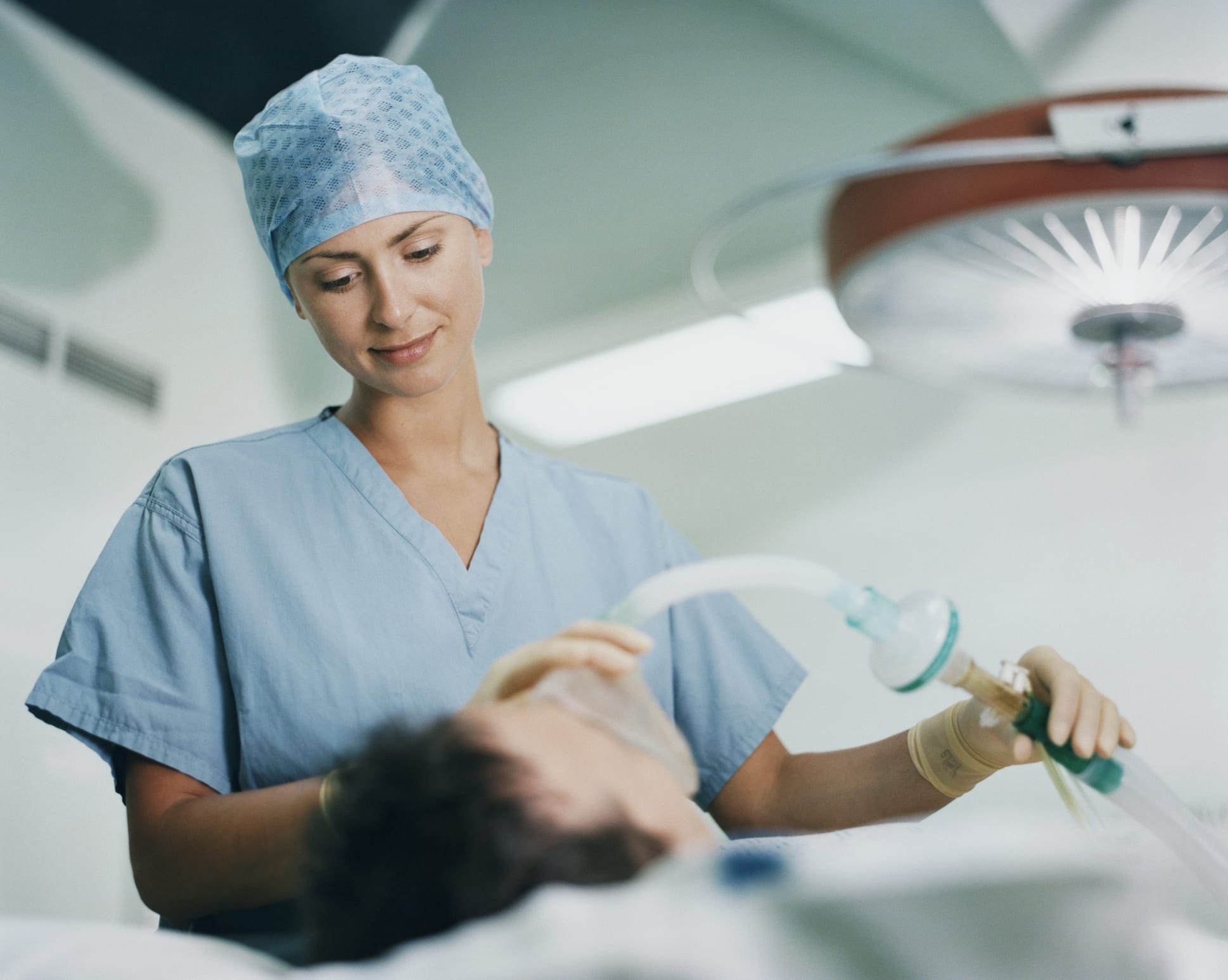 Female Surgeon Holding a Mask on a Patient's Face