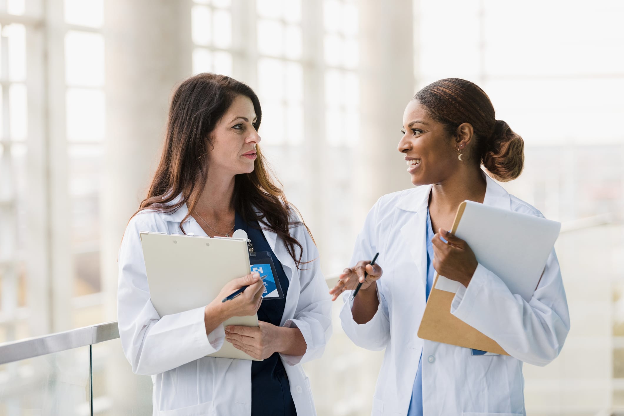 Female healthcare professionals walk and talk together