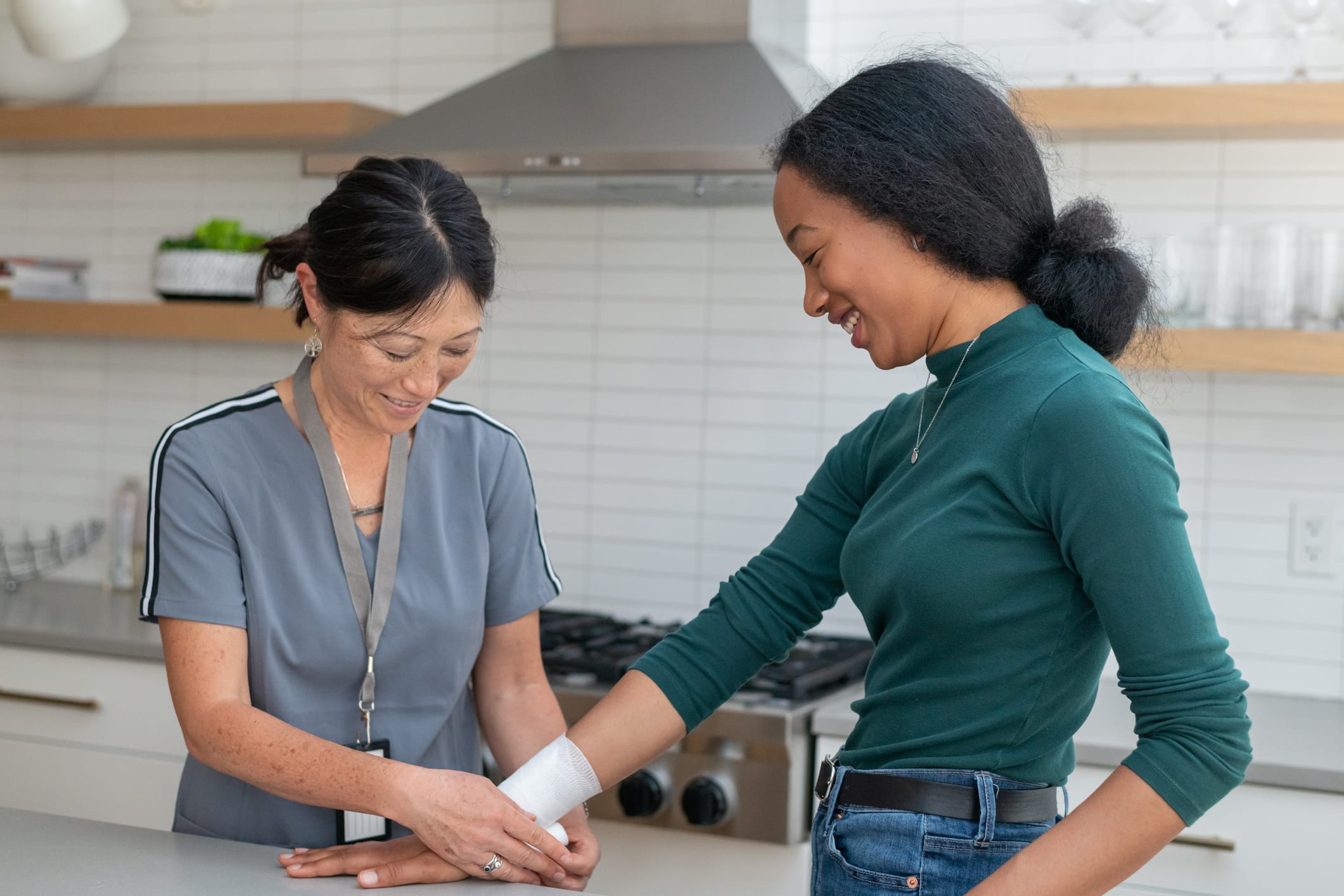 Nurse helping patient with gauze in kitchen