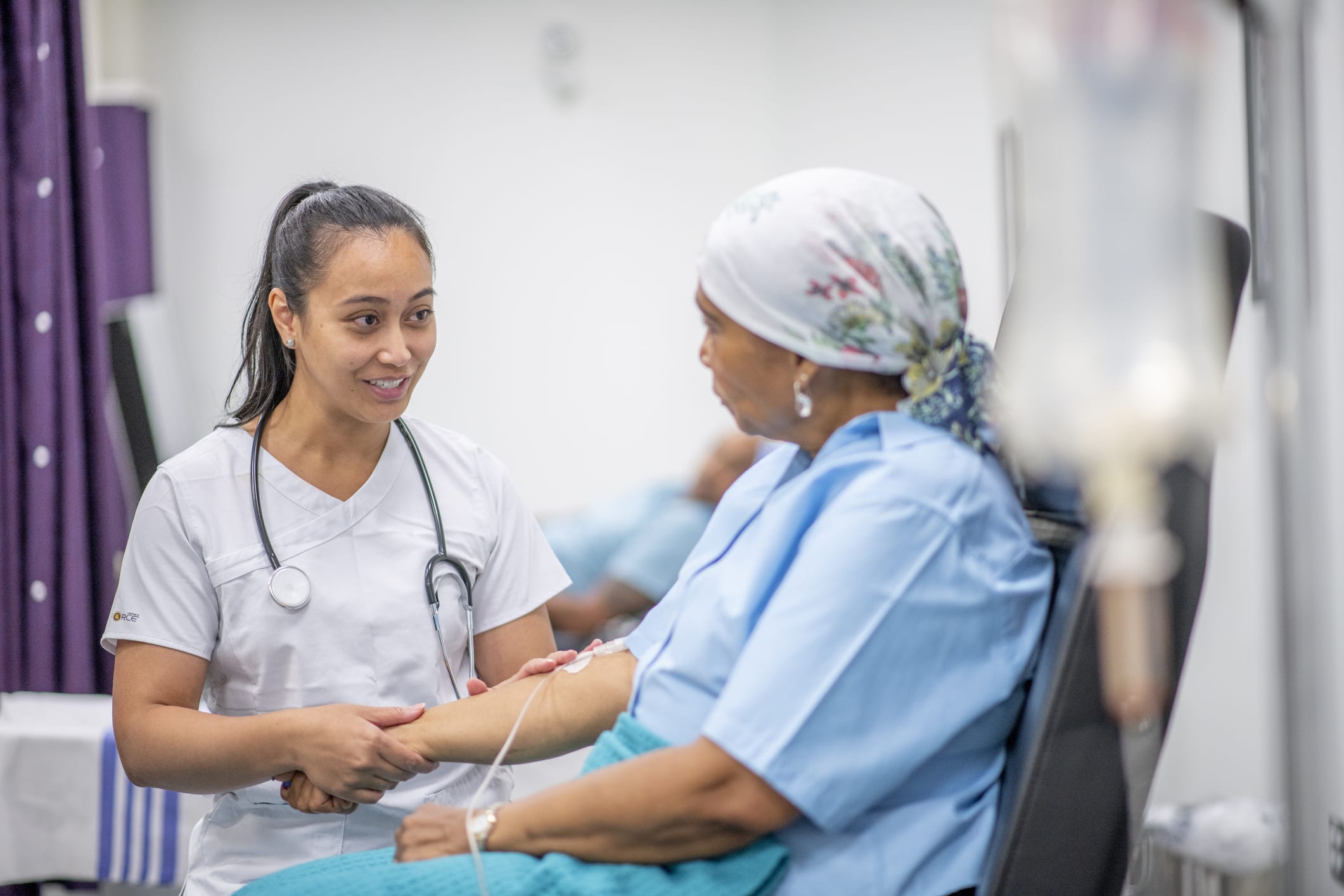 Nurse sitting and speaking with patient