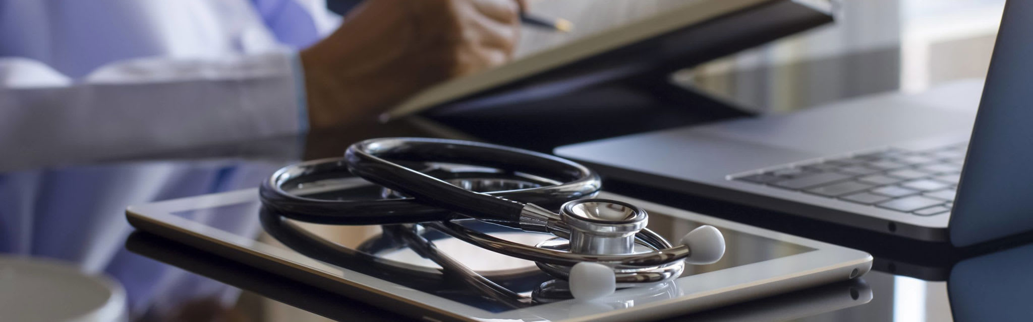 stethoscope on desk next to laptop