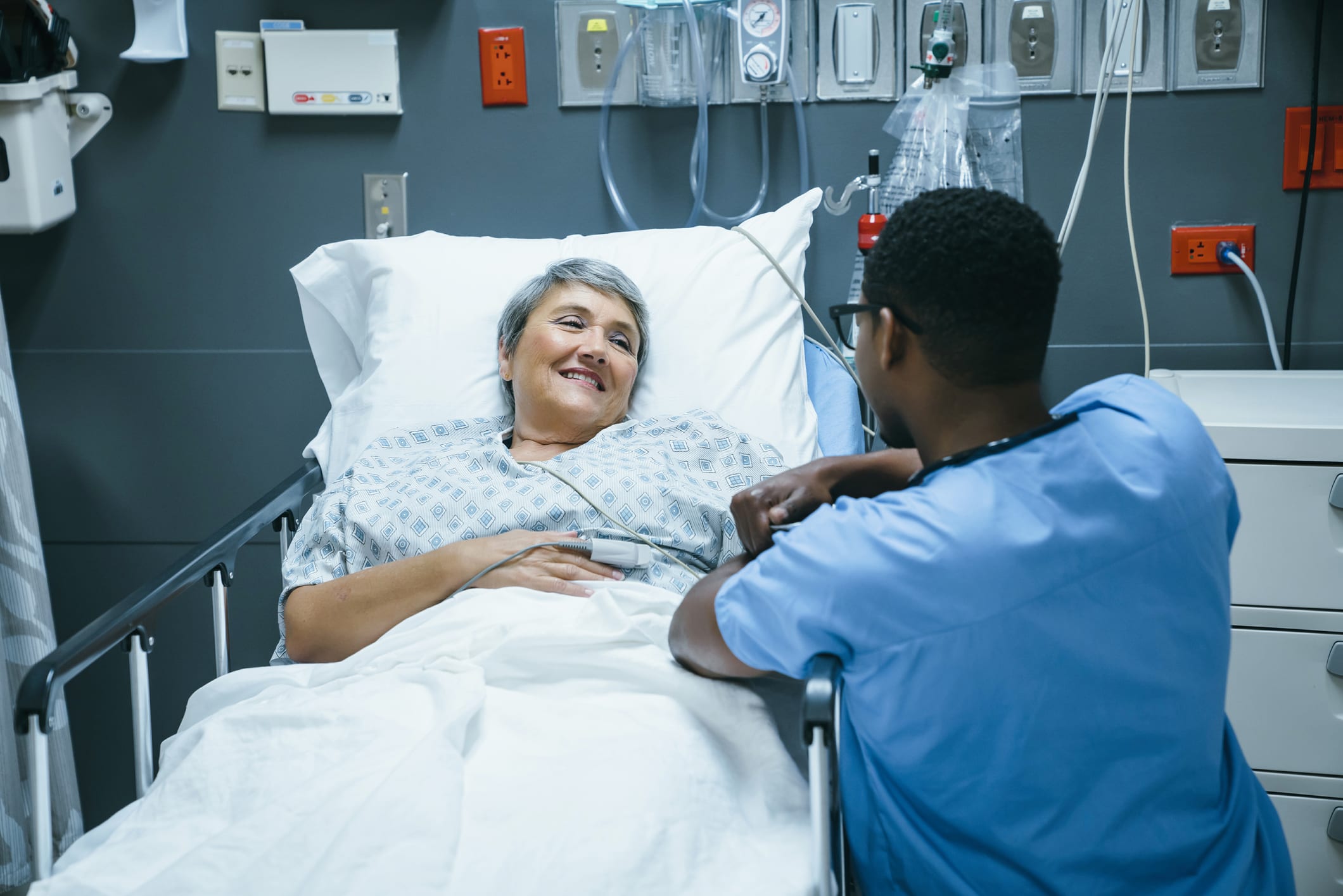 nurse tending to patient waking up in bed