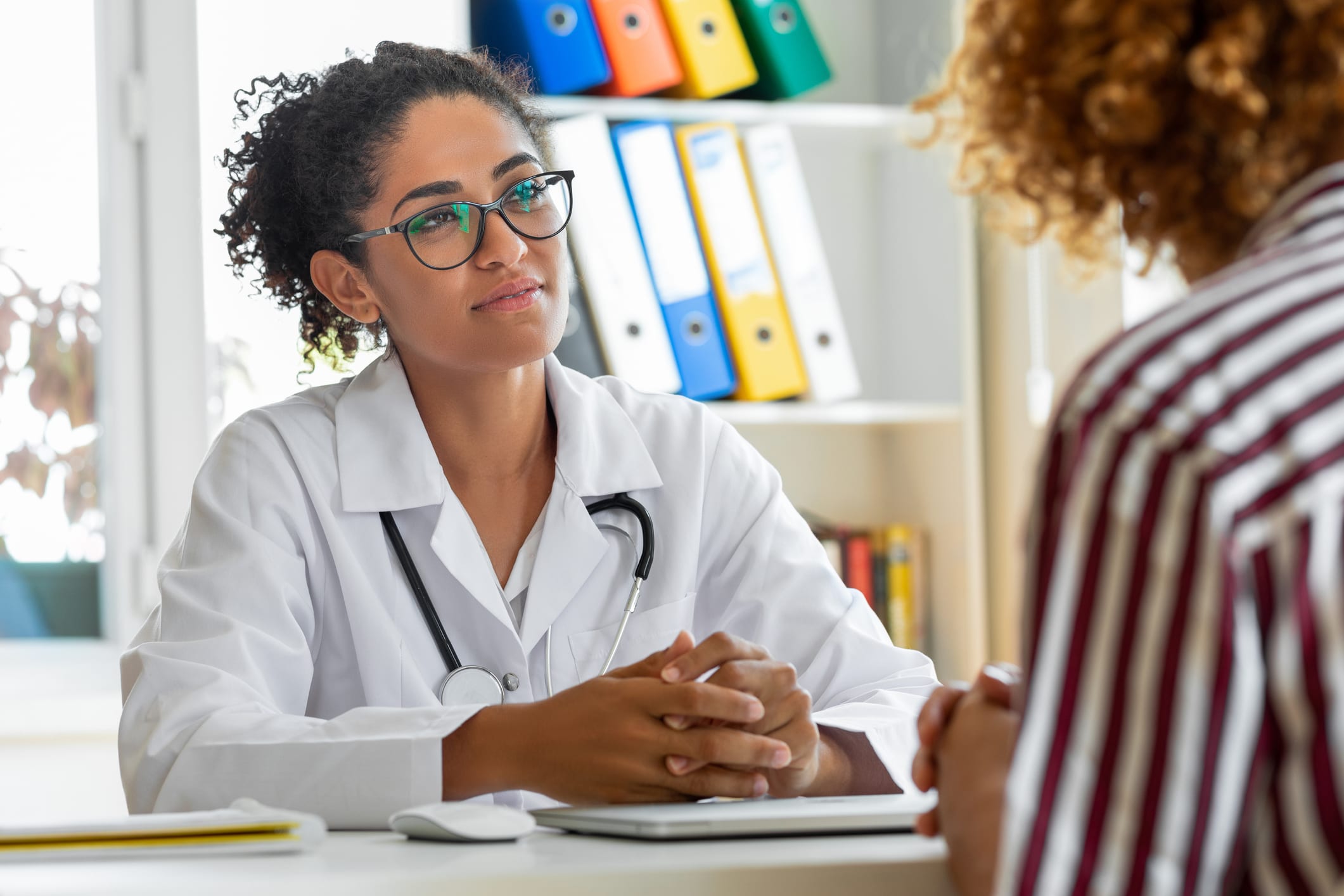 nurse sitting at desk with woman