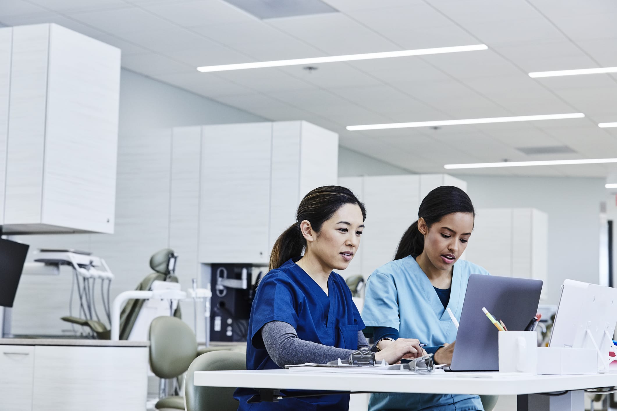 nurses sitting at table looking at computer