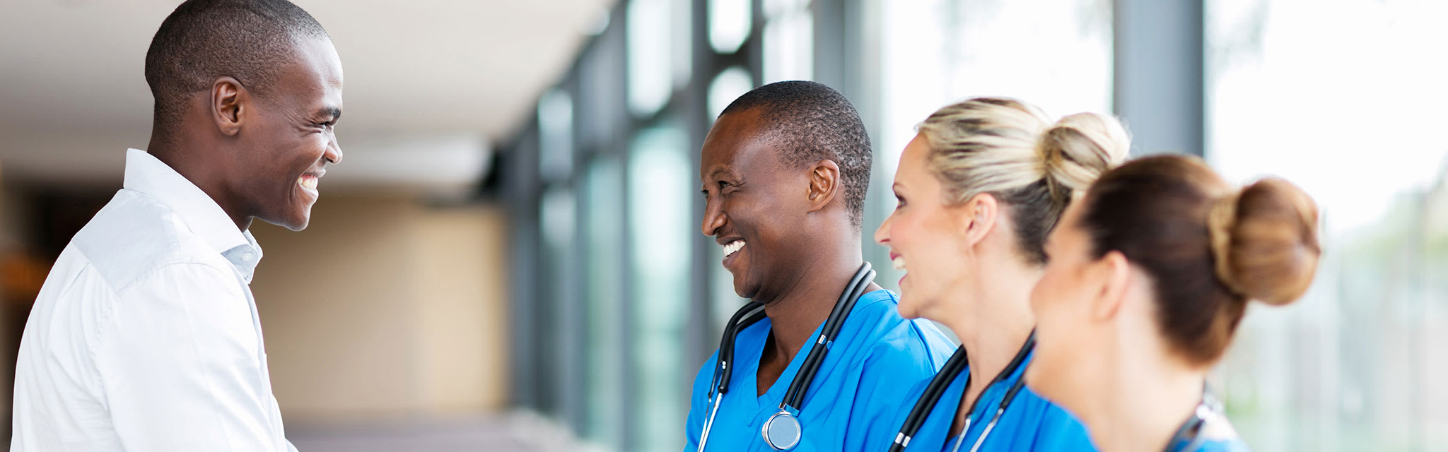 four nurses standing together smiling