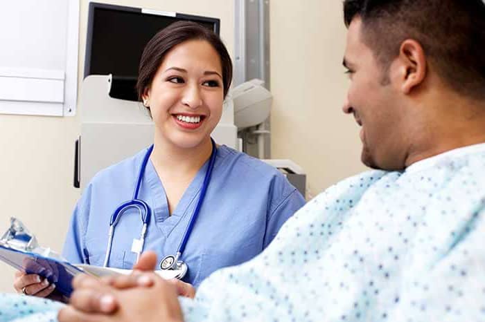 nurse with clipboard speaking to her patient