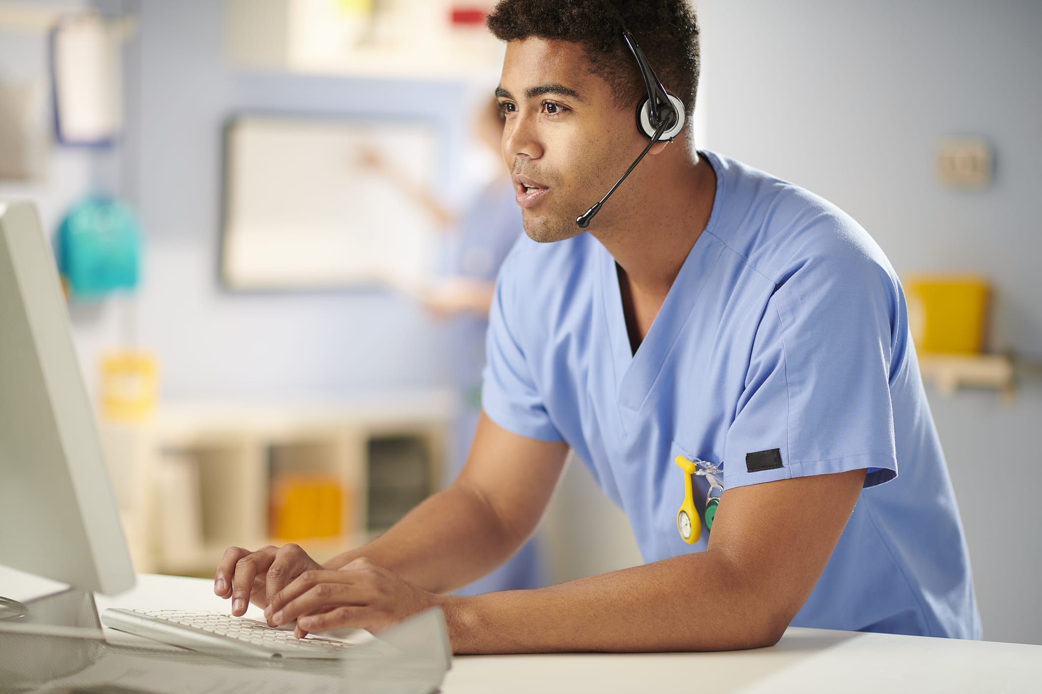 nurse at computer table wearing a headset