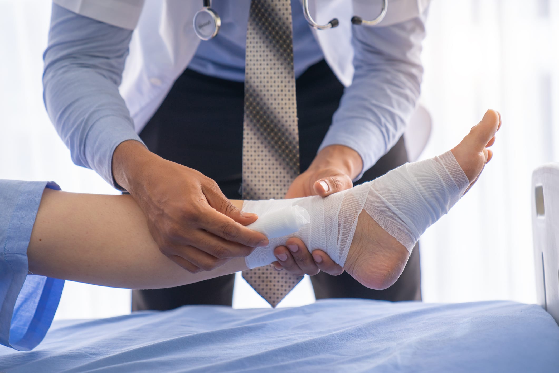 nurse wrapping gauze around patient foot