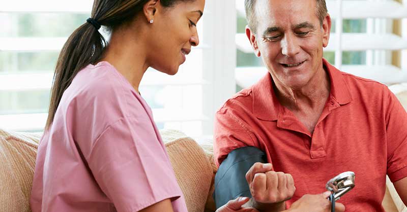 Nurse helping patient with monitoring blood pressure