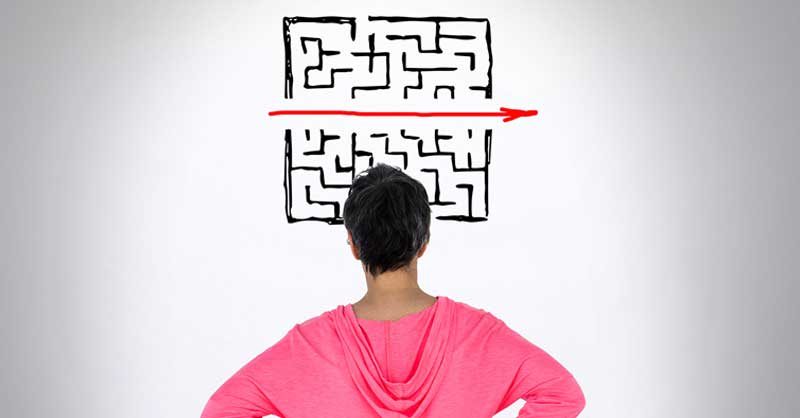 person looking at a drawing on the wall of a maze with a red arrow