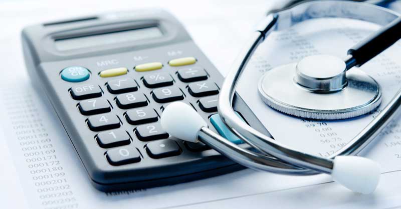 calculator and stethoscope sitting on desk