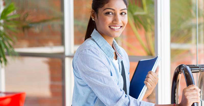 Woman holding binder opening door