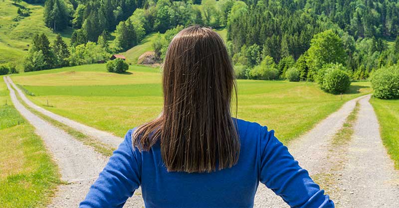 woman standing outside looking at a cross-roads