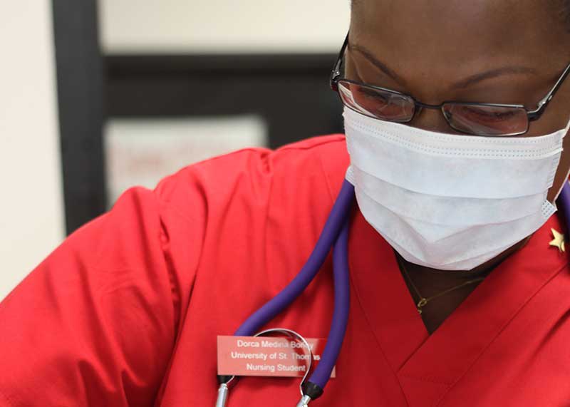 nurse in red scrubs wearing medical mask