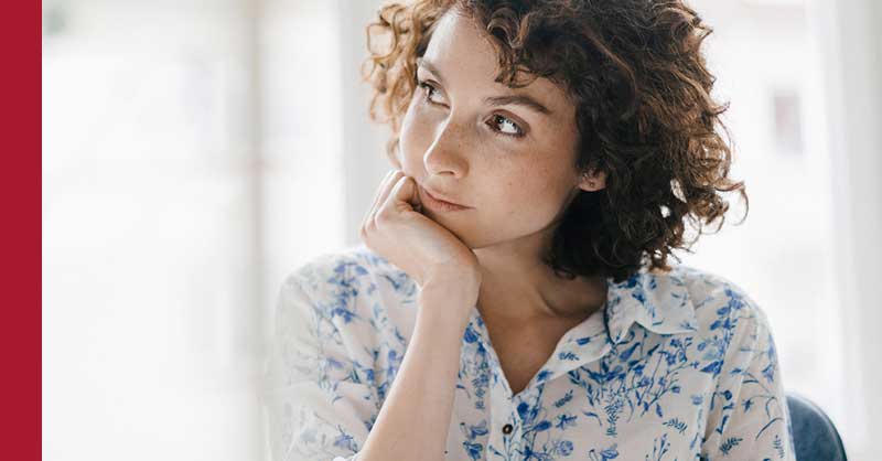 Woman sitting at desk thinking