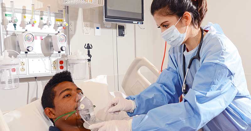 Nurse placing mask on patient