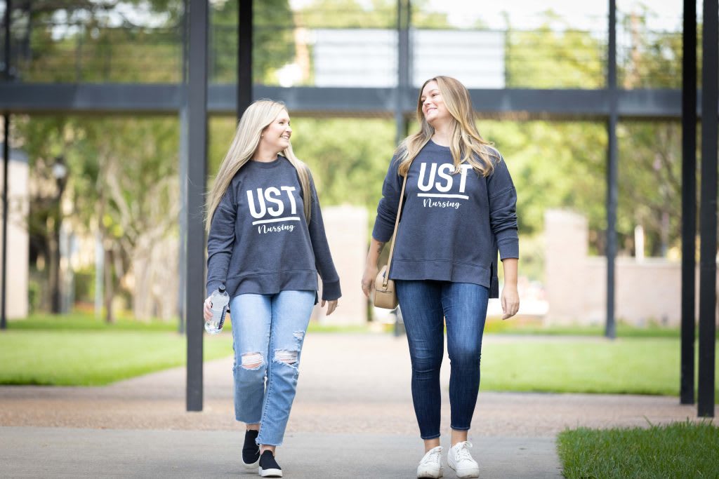 two UST students walking outside on campus