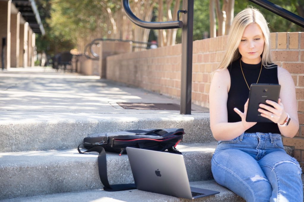 student sitting outside on campus studying