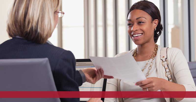 woman handing resume to interviewer