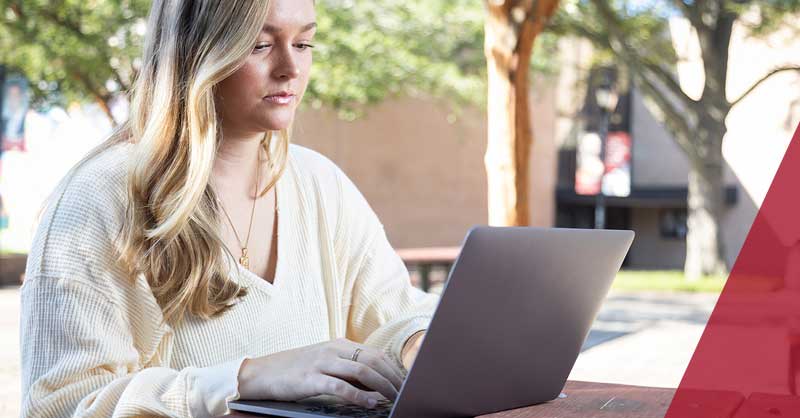 woman sitting outside using laptop