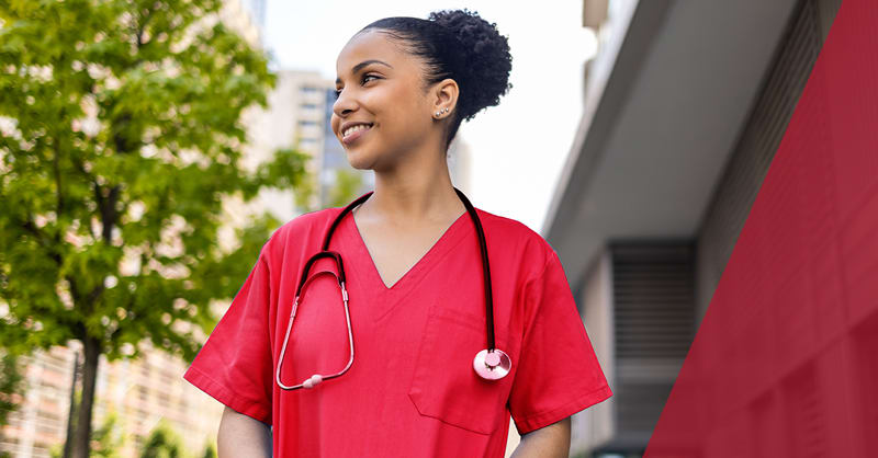 woman wearing red scrubs standing outside