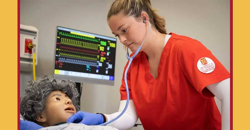 UST nursing student working with sim manikin in lab