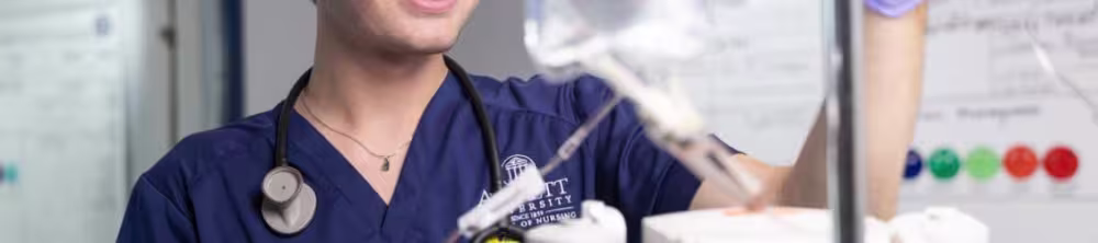 Nursing student smiling setting up a IV bag