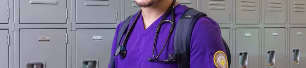 Nursing student smiling in front of lockers