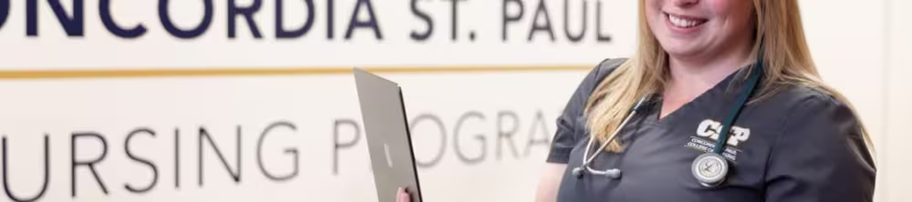 Nurse posing while holding a laptop