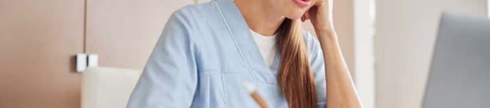 nurse sitting at desk looking at laptop