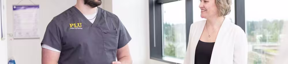 PLU nursing student walking in hall with instructor