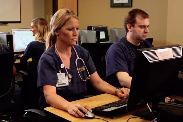 nursing students sitting at desks using computers
