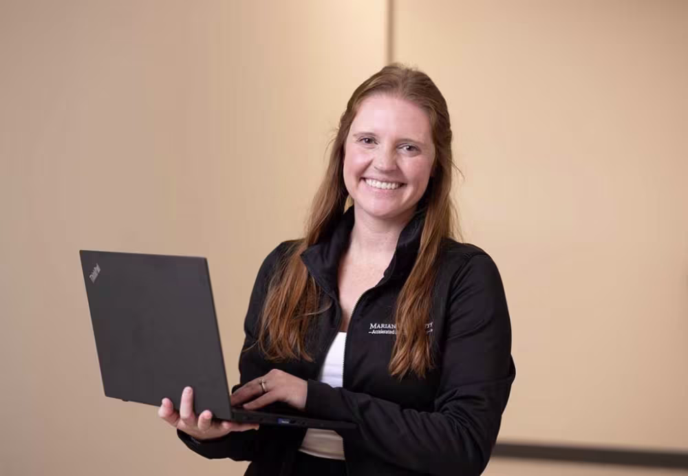 Marian nursing student holding laptop